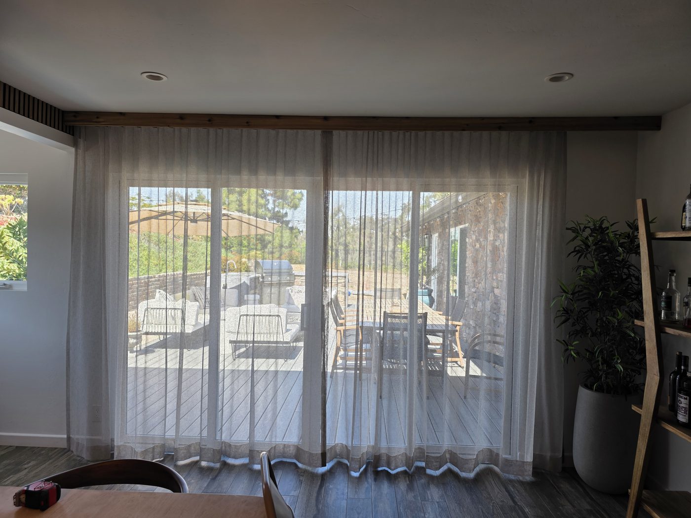 Sheer drapery panels drawn back from a San Diego patio slider