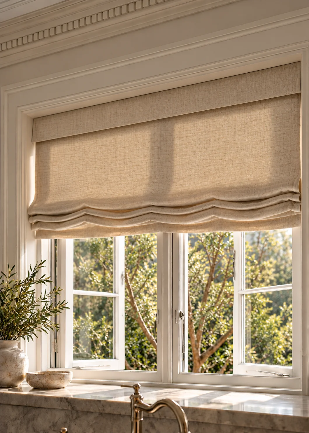 A relaxed linen Roman shade with a softly curved hem on a kitchen window