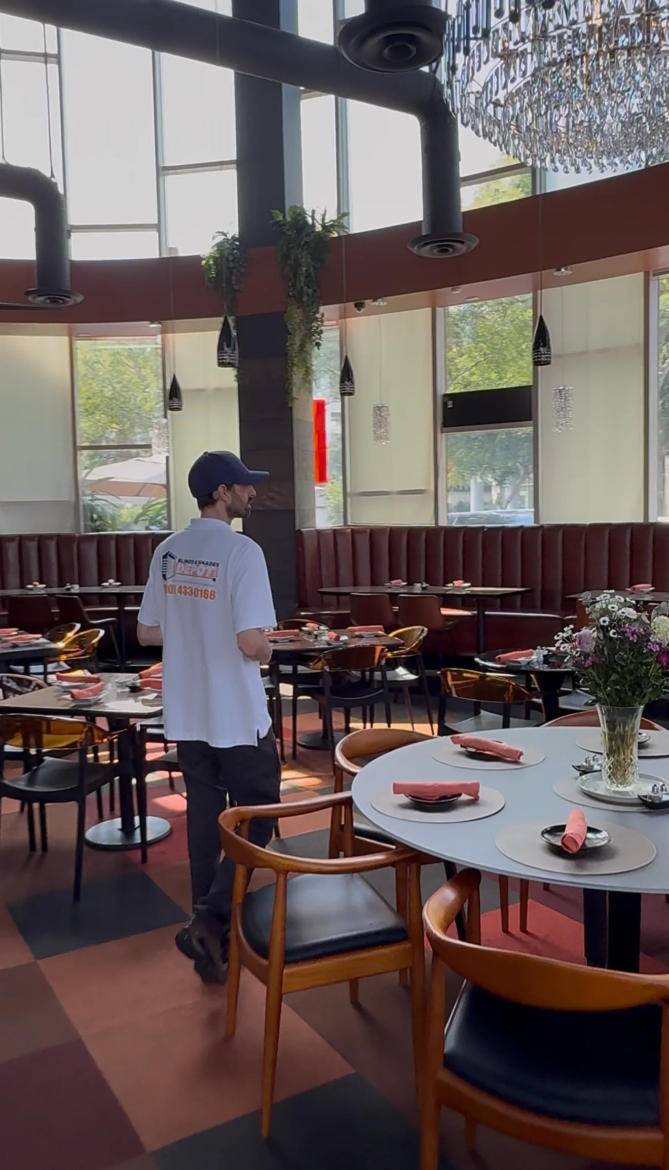 A restaurant dining room with roller shades across the upper glass