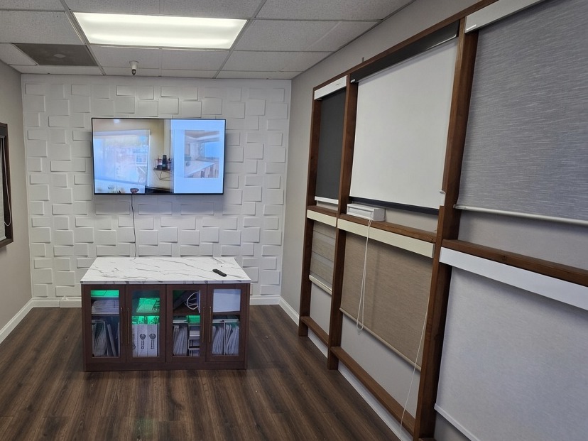 San Diego showroom interior with a wall of roller shade samples, a TV and a marble sample counter